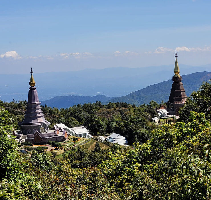 Two large Pagodas with pointed turrets stand high above the thick tree line in Doi Inthanon National Park, Thailand