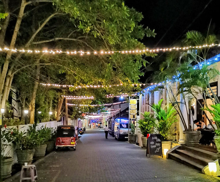 String lights are hung across the road between trees and buildings in Galle Fort, Sri Lanka