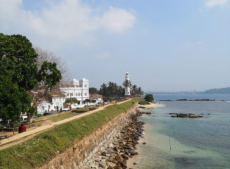 A coastal path, with a small lighthouse at the end of the ridge.