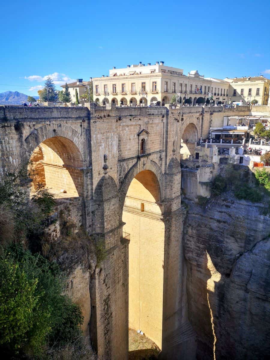 A vast stone arched bridge stands in a 120m gorge, with the town on either side in Ronda, Spain
