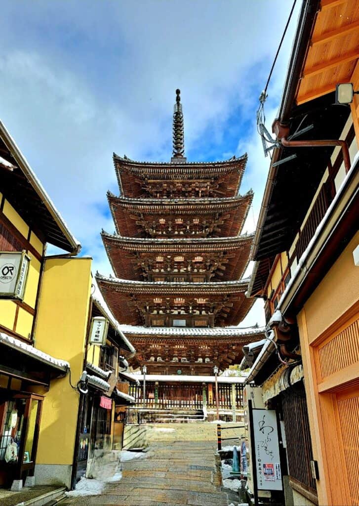 A traditional Japanese wooden Pagoda is frame by traditional houses in the Gion District, Kyoto